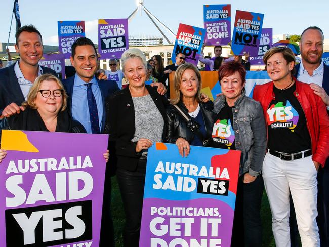 Australian Olympic swimmer Ian Thorpe (L) joins equality ambassadors and volunteers from the Equality Campaign who gather in front of Parliament House in Canberra on December 7, 2017, ahead of the parliamentary vote on Same Sex Marriage, which will take place later today in the House of Representatives.   / AFP PHOTO / SEAN DAVEY