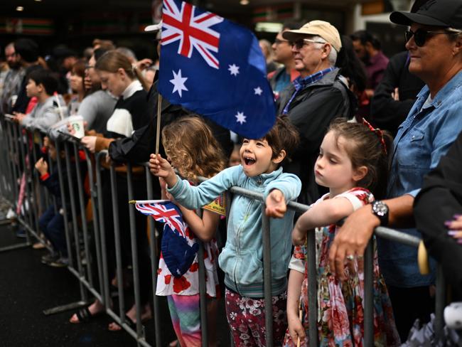 A child waves the Australian flag as crowds watch the parade. Picture: Dan Peled/Getty Images