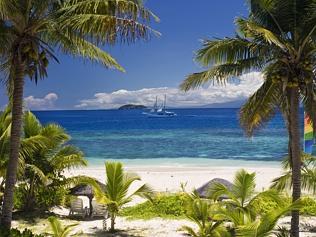 Sail boat seen through palm trees, Mamanuca Group islands, Fiji