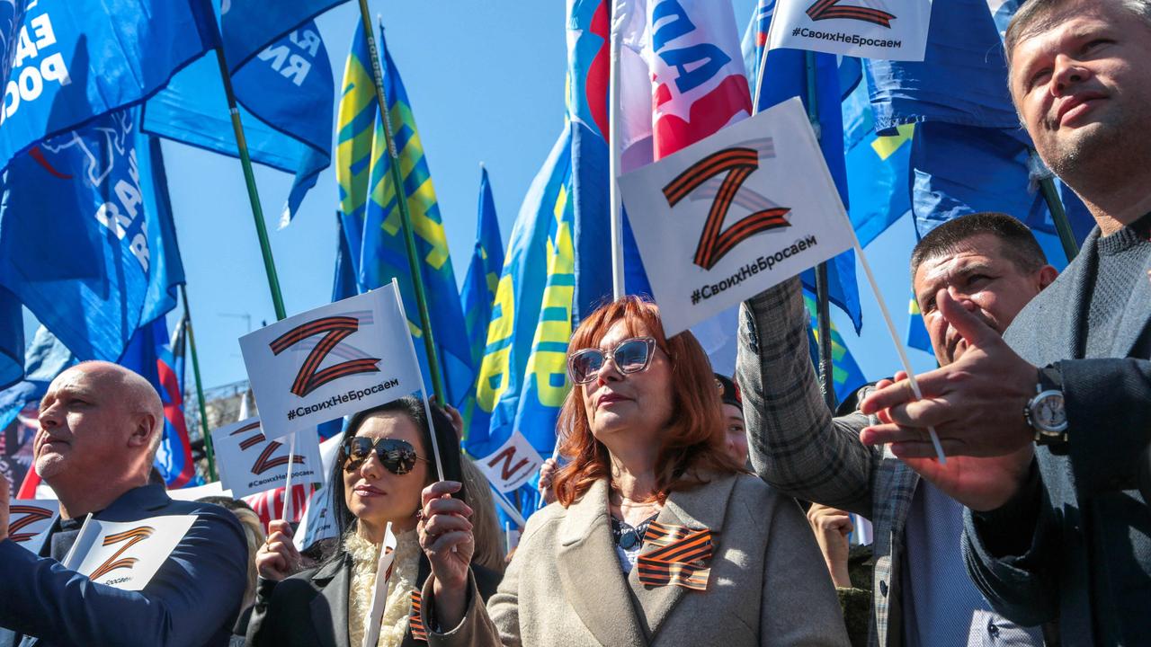 People wave flags during a rally in support of the Russian military operation in Ukraine, in Simferopol, Crimea on April 7, 2022. Photo Credit: AFP.