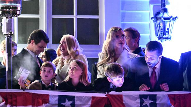 Michael Boulos (2L) and his wife Tiffany Trump (3L) share a laugh as Donald Trump Jr. (R) gestures with family children during a firewirks reception in honor US President-elect Donald Trump at Trump National Golf Club Washington DC in Sterling, Virginia.