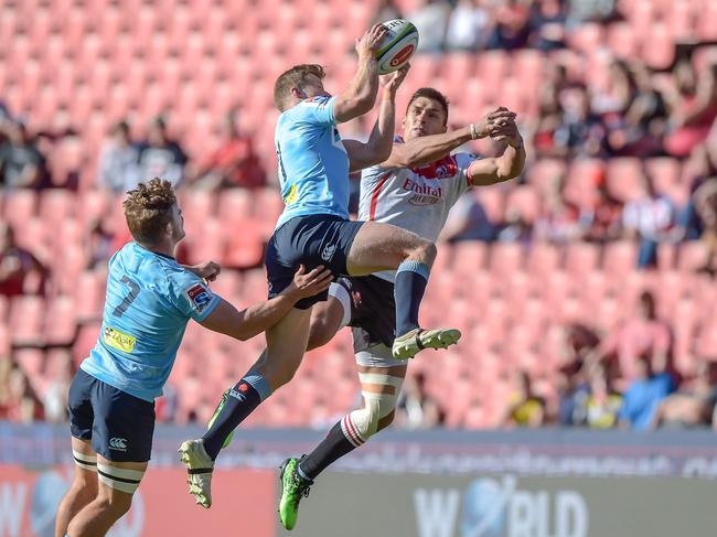 The NSW Waratah's Alex Newsome (C-L) and The Emirates Lions' Harold Vorster (C-R) contest for the ball. Picture: Christiaan Kotze/AFP