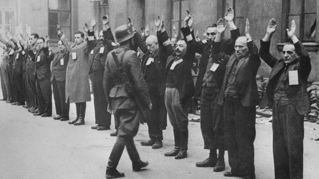 A Nazi SS guard inspects Jewish workers in April 1943, when the Warsaw ghetto uprising began.