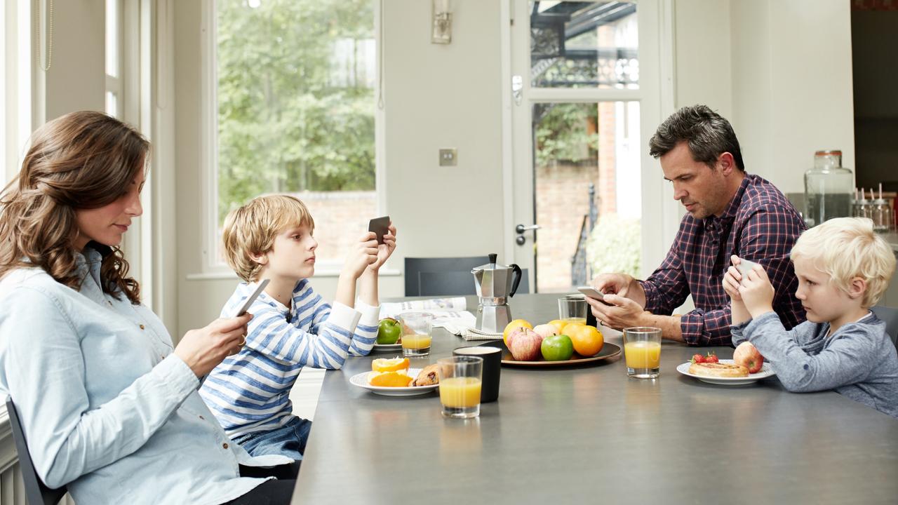 No conversation happening here: many families report reluctance to put down their phones while they’re eating meals. Picture: iStock