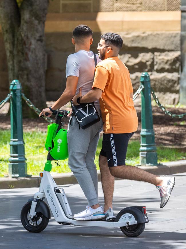 Two young men ride a scooter. Picture: Jake Nowakowski