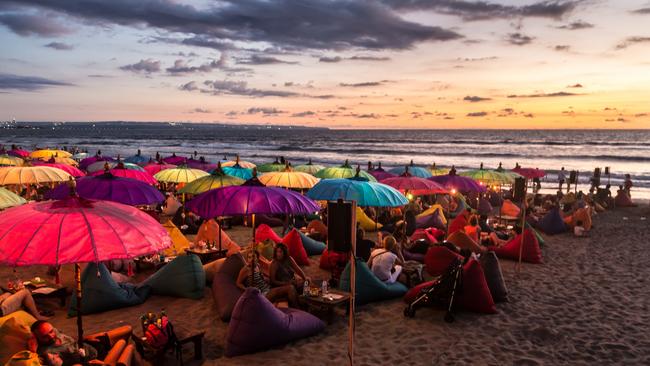 Kuta, Indonesia - February 19, 2016: A large crowd of tourists enjoy the sunset at a beach bar on Kuta beach in Seminyak, Bali. The island is famous for its nightlife. Image: iStock