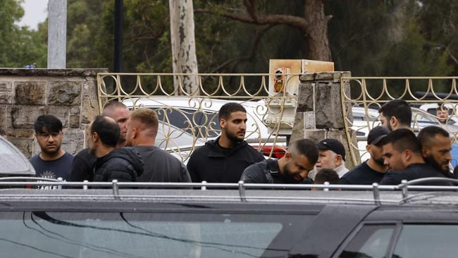 Mourners bow their heads near the hearse bearing Acherkouk’s coffin.