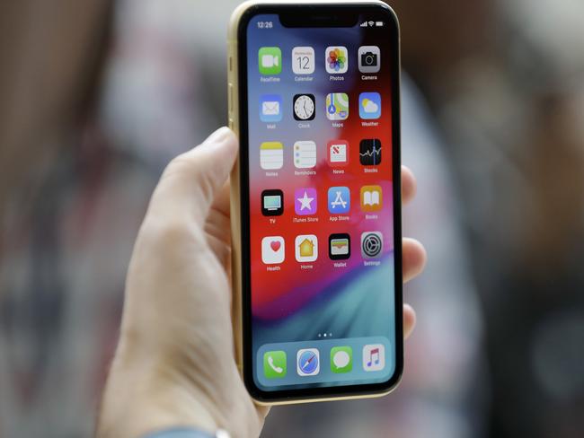 FILE - An Apple iPhone XR is held at the Steve Jobs Theater after an event to announce new products, in Cupertino, Calif. (AP Photo/Marcio Jose Sanchez, File)