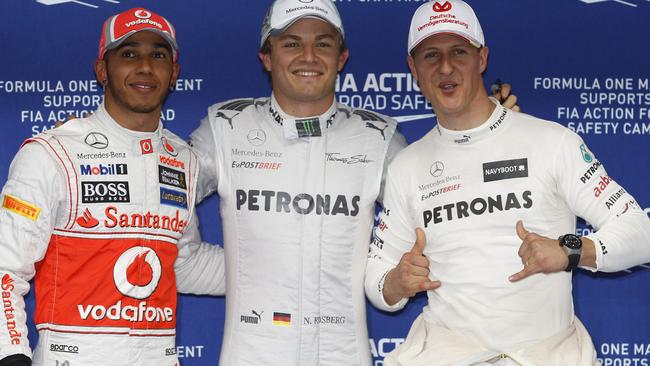 Nico Rosberg celebrates with teammate and compatriot Michael Schumacher and Lewis Hamilton