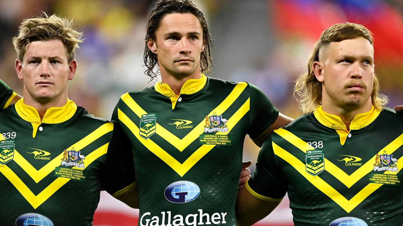 TOWNSVILLE, AUSTRALIA - OCTOBER 14: Harry Grant, Nicho Hynes and k17of the Kangaroos stand for the national anthem before the Mens Pacific Championship match between Australia Kangaroos and Samoa at Queensland Country Bank Stadium on October 14, 2023 in Townsville, Australia. (Photo by Ian Hitchcock/Getty Images)