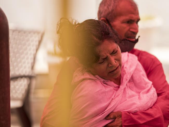 A woman reacts in discomfort after she arrived to receive free oxygen distributed as a service by a Gurdwara. Picture: Getty Images