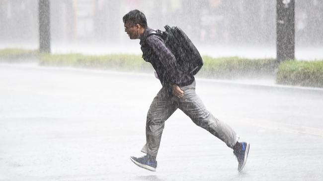 Pedestrian caught in the rain on King William St. Picture: Bernard Humphreys