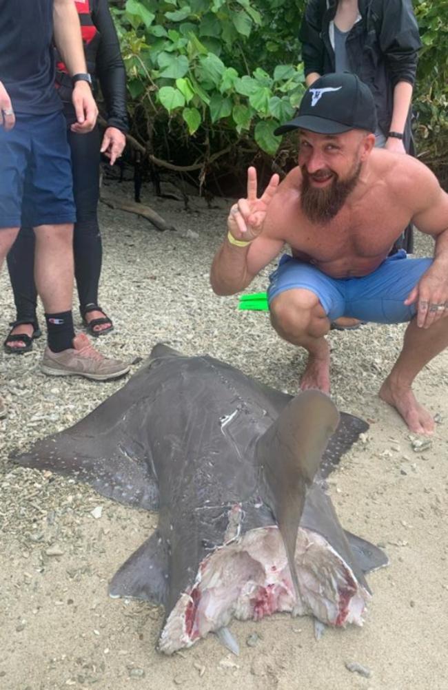 Personal trainer Conan Maestrom posed with the remains of the shovelnose shark two hours after witnessing a hammerhead attack it in the water.