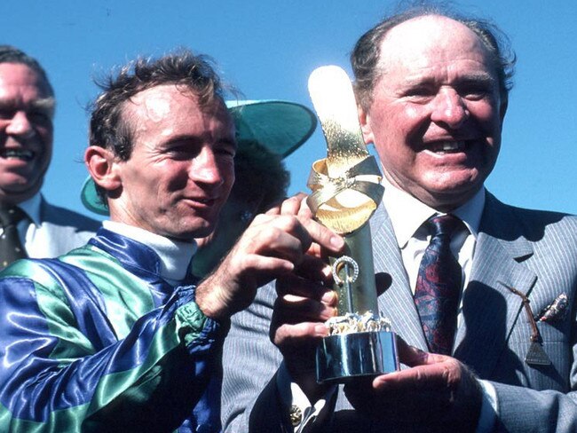 Trainer Tommy (Tom) Smith with jockey Len (Mick) Dittman with Golden Slipper trophy at presentation after they combined to win the race with racehorse Bounding Away at Rosehill Gardens Racecourse, Sydney in a 1986 photo.