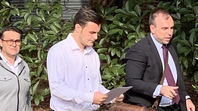 Semih Parlak (centre) with his lawyer and father outside court.