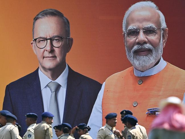 Police personnel stand next to a poster with the pictures of Anthony Albanese and Indian Prime Minister Narendra Modi at the Narendra Modi stadium in Ahmedabad. Picture: Punit PARANJPE / AFP