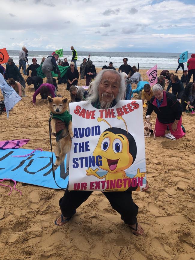 Danny Lim, 76, and his dog Smarty, at the Extinction Rebellion at Manly Beach. Picture: Julie Cross.