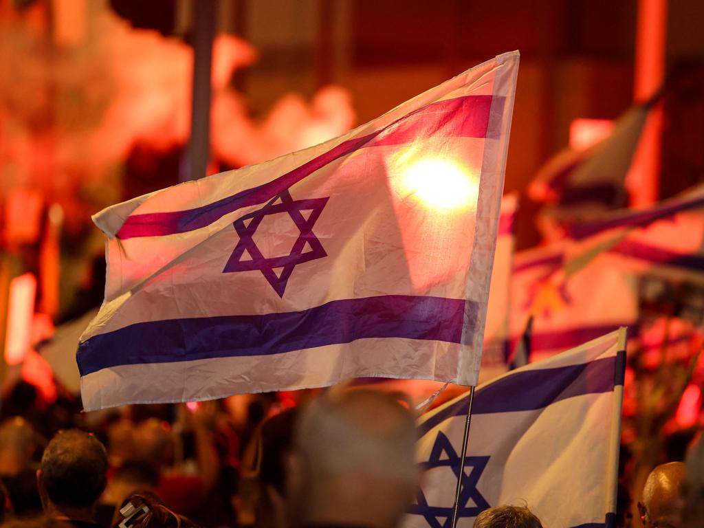 Demonstrators light flares and wave national flags during an anti-government protest calling for action to secure the release of Israeli hostages held captive since the October 7 attacks. Picture: AFP