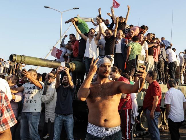 Getty Images Year in Focus 2016: Supporters of Turkish President Recep Tayyip Erdogan wave flags as they capture anTurkish Army APC after soldiers involved in the coup surrendered on Bosphorus bridge on July 16, 2016 in Istanbul, Turkey. Istanbul’s bridges across the Bosphorus, the strait separating the European and Asian sides of the city, have been closed to traffic. Turkish President Recep Tayyip Erdogan has denounced an army coup attempt, that has left atleast 90 dead 1154 injured in overnight clashes in Istanbul and Ankara. Photo by Stringer/Getty Images