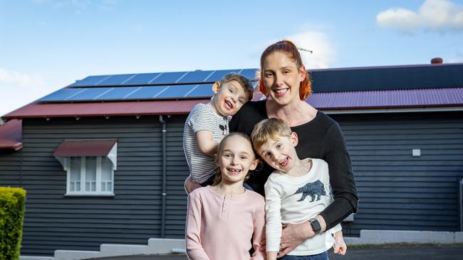 Lauren Daley and children Winston (age 3), Charlotte (age 7) and Angus (age 5) with solar panels at their Clayfield home. Picture: Richard Walker