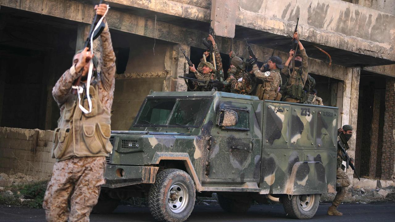 Anti-government fighters shoot into the air in a street in Maaret al-Numan in Syria's northwestern Idlib province. Picture: AFP