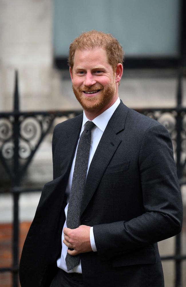 Flanked by bodyguards, Prince Harry was all smiles. Picture: AFP