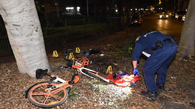 An officers searches items left at the scene. Picture: Gordon McComiskie