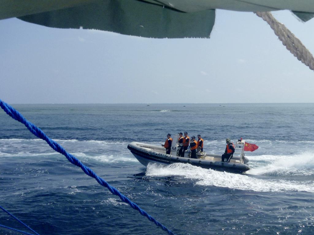 A Chinese Coast Guard boat circles a Filipino fishing boat near Scarborough Shoal in the South China Sea. Picture: AP