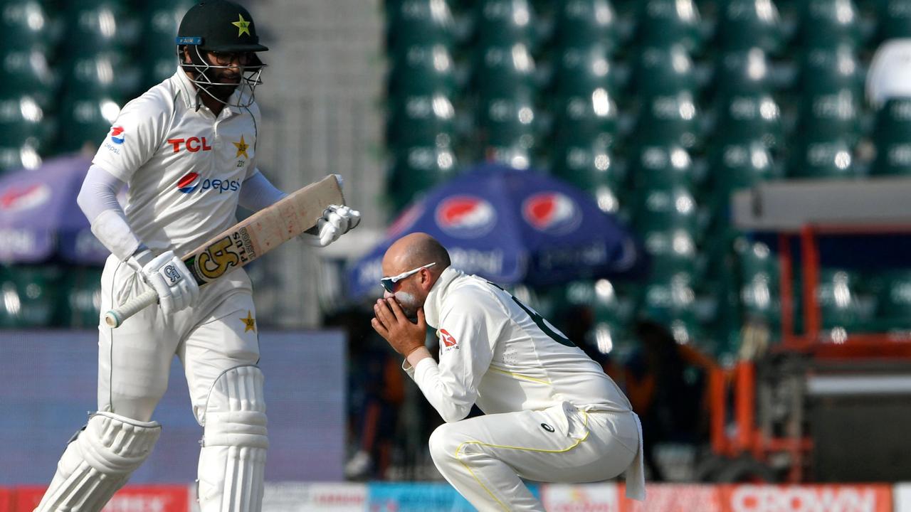 Australia's Nathan Lyon (R) reacts next to Pakistan's Imam-ul-Haq during the fourth day of the third and final Test cricket match between Pakistan and Australia at the Gaddafi Cricket Stadium in Lahore on March 24, 2022. (Photo by Aamir QURESHI / AFP)