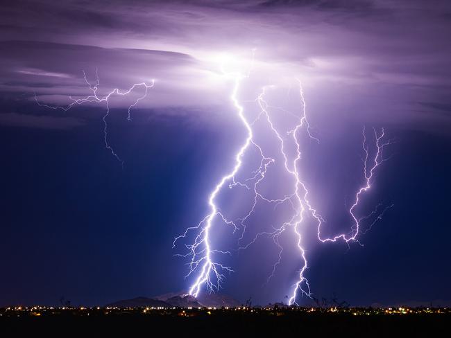 Lightning bolt storm with thunderstorm clouds at night.