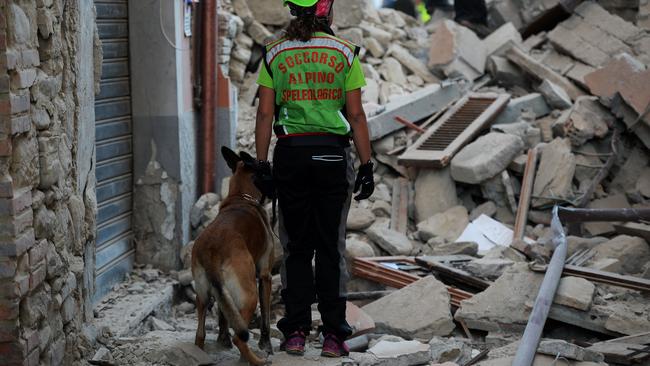 Rescuers search for victims among the rubble of a house. Picture: Filippo Monteforte.