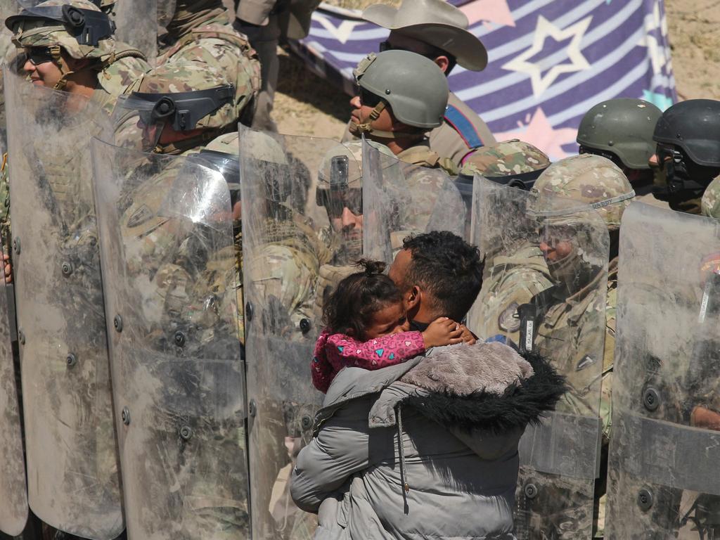 A Venezuelan father retreats with his daughter as Texas National Guard and highway police block migrants at the Rio Grande, Mexico. Picture: Herika Martinez/AFP