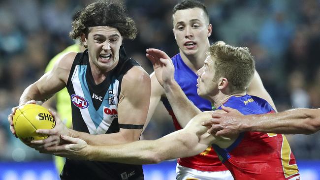 Port Adelaide’s Darcy Byrne-Jones tries to get past Brisbane’s Ryan Harwood. Picture SARAH REED