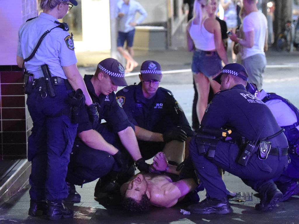 NSW Police officers subdue a man under the influence of methamphetamine on Kent St, in the Sydney CBD. Early reports stated that the offender had ripped out a piece of industrial piping and was threatening to stab pedestrians with it.  Picture: Gordon McComiskie