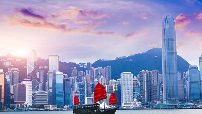 Sailboat travel to Hong Kong Victoria Harbour at sunset.