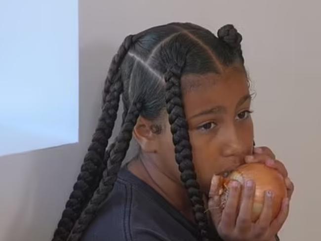 North West shocked Kim by biting into a raw onion. Picture from YouTube.