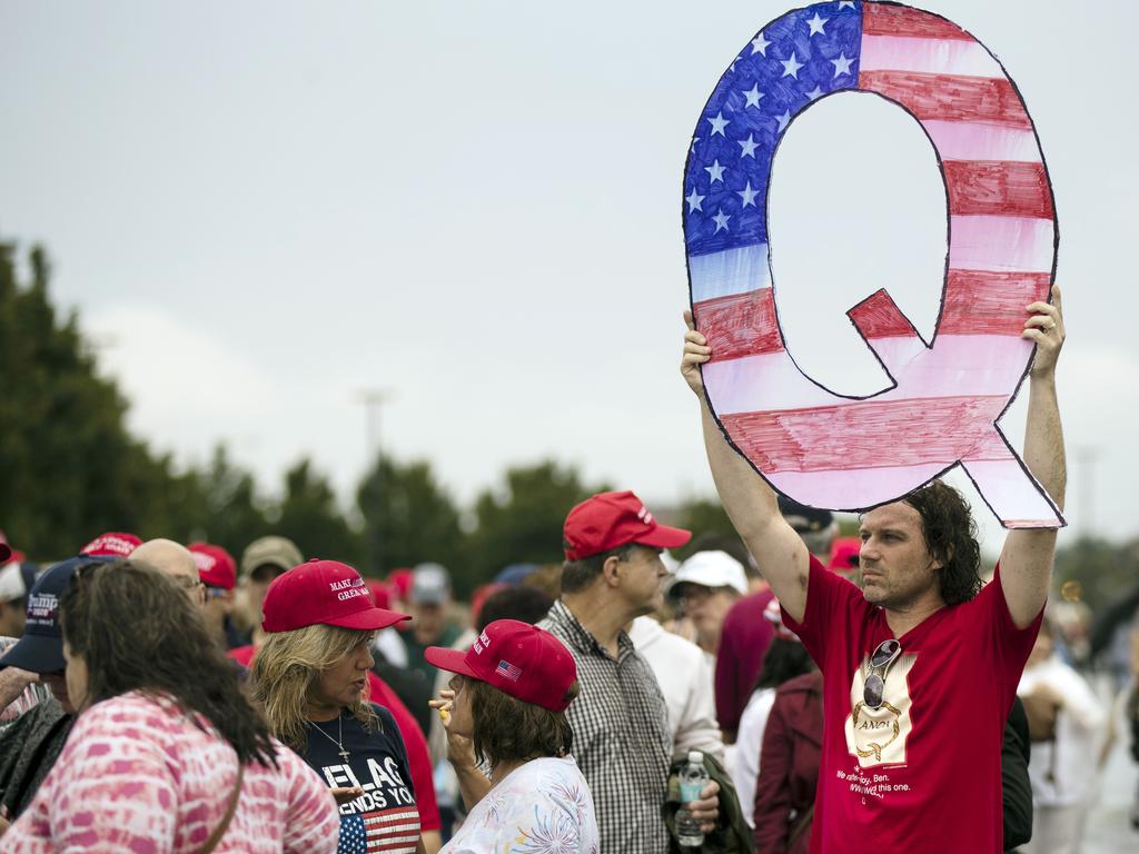 David Reinert holding a Q sign waits in line with others to enter a campaign rally with President Donald Trump in 2018. Picture: AP Photo/Matt Rourke, File.