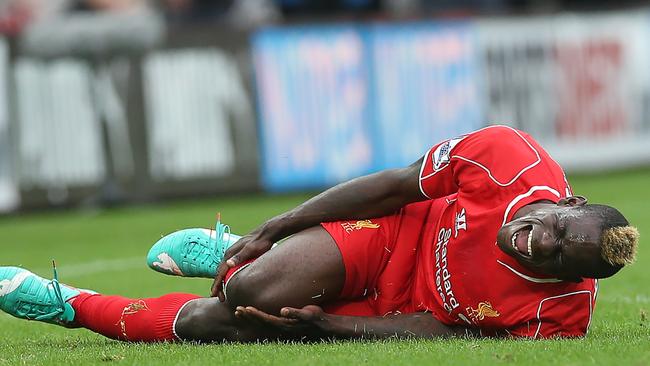 Liverpool's Italian striker Mario Balotelli reacts to an injury.