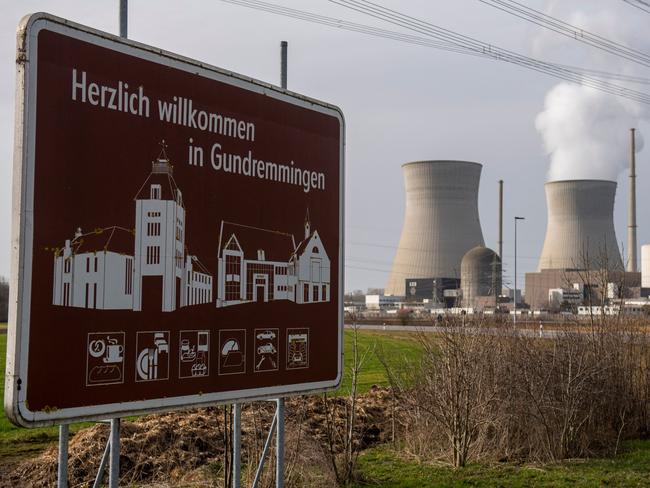 A shield reading 'Welcome in Gundremmingen' is pictured in front of a nuclear powerplant in Gundremmingen, southern Germany on February 26, 2021. - The Bavarian village of Gundremmingen is still proud of its nuclear power plant, whose coat of arms bears a golden atom. But a page will be turned with the upcoming closure of this facility to accompany Germany in its energy revolution. (Photo by LENNART PREISS / AFP)