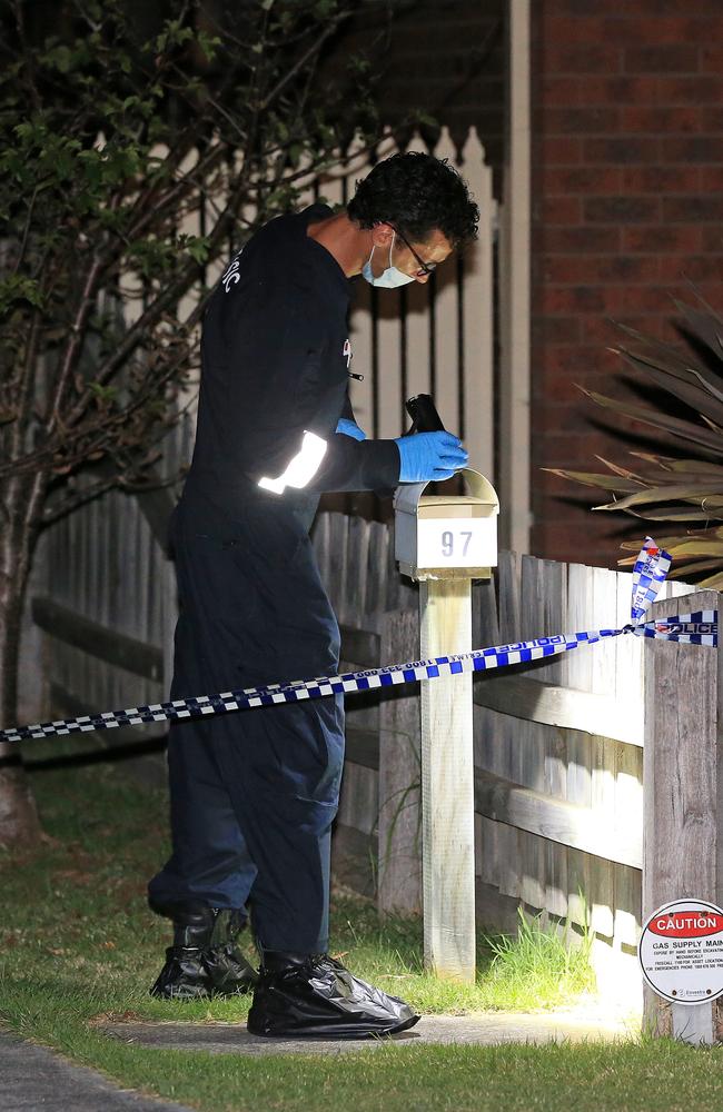 A forensic detective inspects a letterbox. Picture: Mark Stewart