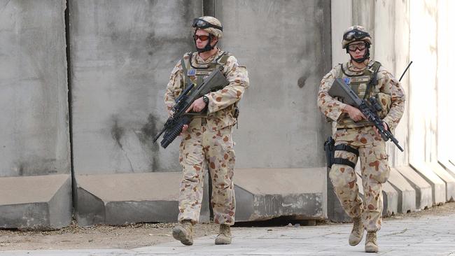 Australian infantry soldiers from 1RAR walk the streets of Baghdad on patrol.