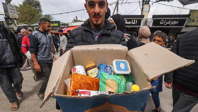 A man presents the contents of a cardboard box of food aid provided by non-profit non-governmental organisation World Central Kitchen in Rafah. Picture: Mohammed Abed/AFP