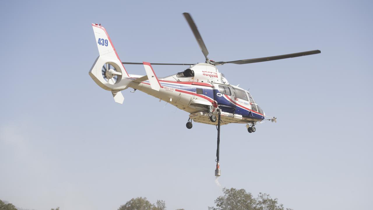 A water tanker helicopter picks up water at Moriarty Park Hall in Canungra on Saturday. Picture: AAP Image/Aaron Bunch