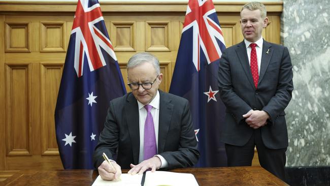 Anthony Albanese signs a visitors book while New Zealand Prime Minister Chris Hipkins looks on during a welcome ceremony at parliament in Wellington.