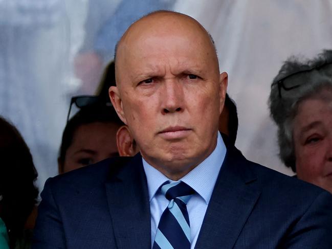 Mr Dutton held a flower as he attended the ceremony in Coogee. Picture: David Gray / AFP