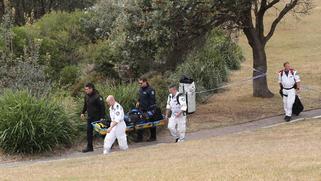 Police carry a stretcher of equipment on their way to retrieve a body found at the base of cliffs at Diamond Bay, Vaucluse, believed to be linked to the murder of young Sydney teacher Lilie James. Picture: NCA NewsWire / Max Mason-Hubers