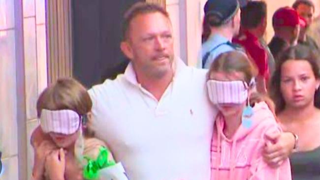 Chris Walsh walking his children out of Westfield after the attacks. Image: news.com.au