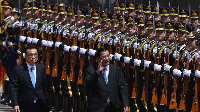 Cambodia's Prime Minister Hun Sen (C) reviews a military honour guard with Chinese Premier Li Keqiang (L) during a state visit to China after attending the Belt and Road Forum. Picture: AFP PHOTO.