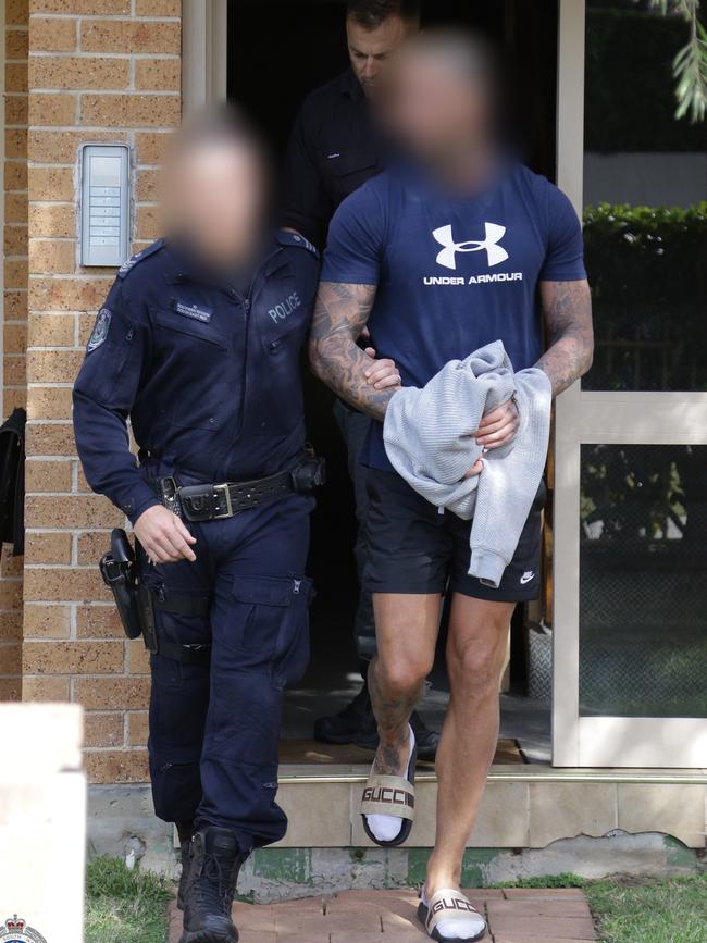 James Booth, wearing Gucci slides, is taken into custody on Wednesday. Picture: NSW Police