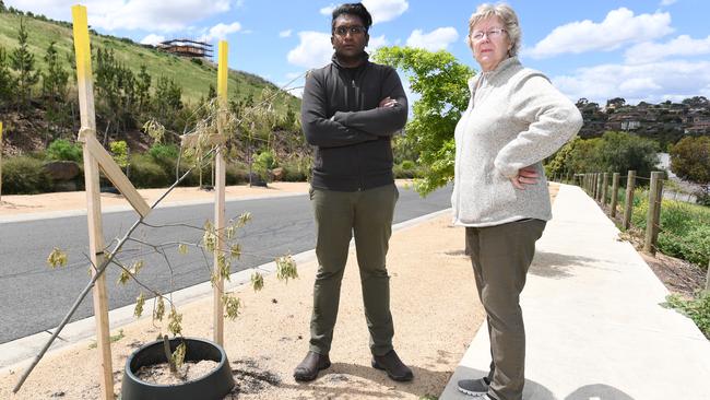 Gowanbrae residents Shanaka Perera and Cheryl Arnett with one of the 46 trees vandalised in Primula Blvd. Picture: James Ross